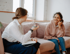 Two women talking on a couch during a family counseling session
