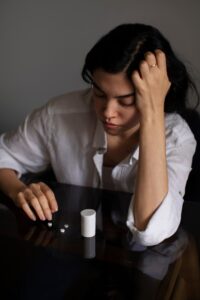 Young woman sitting with her head down, struggling with anxiety